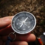 A traveler holds a compass in his hand to determine the direction of his movement